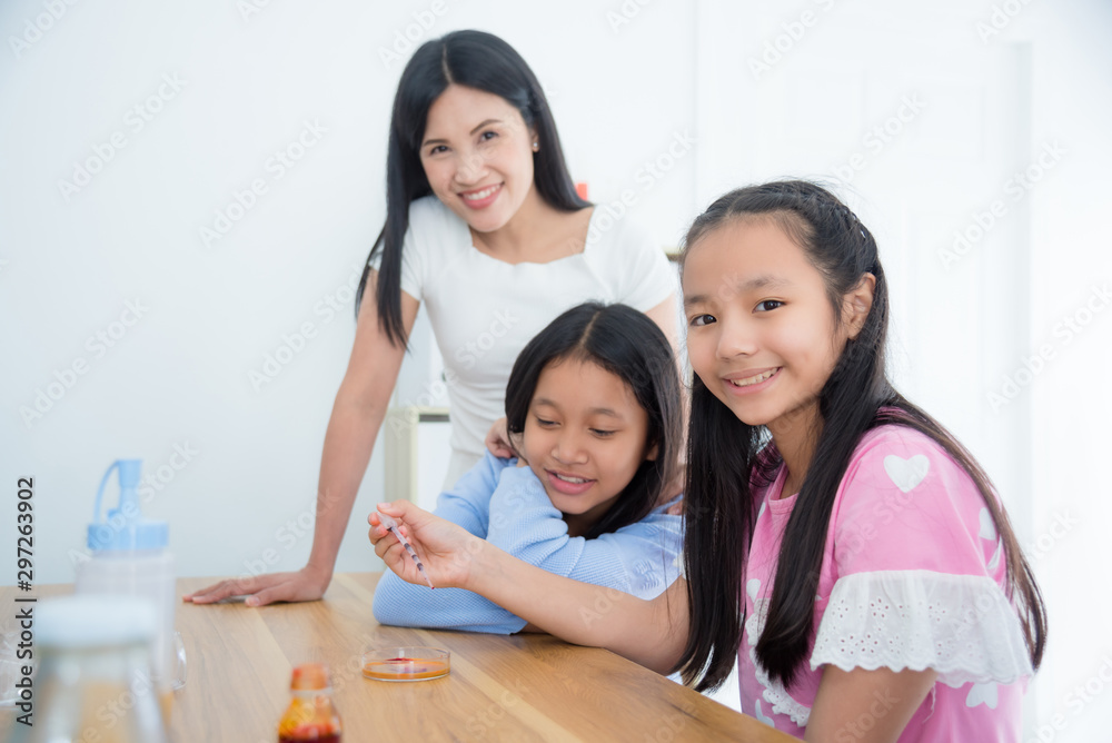 Young asian schoolgirl study science experiment with friend and teacher at school