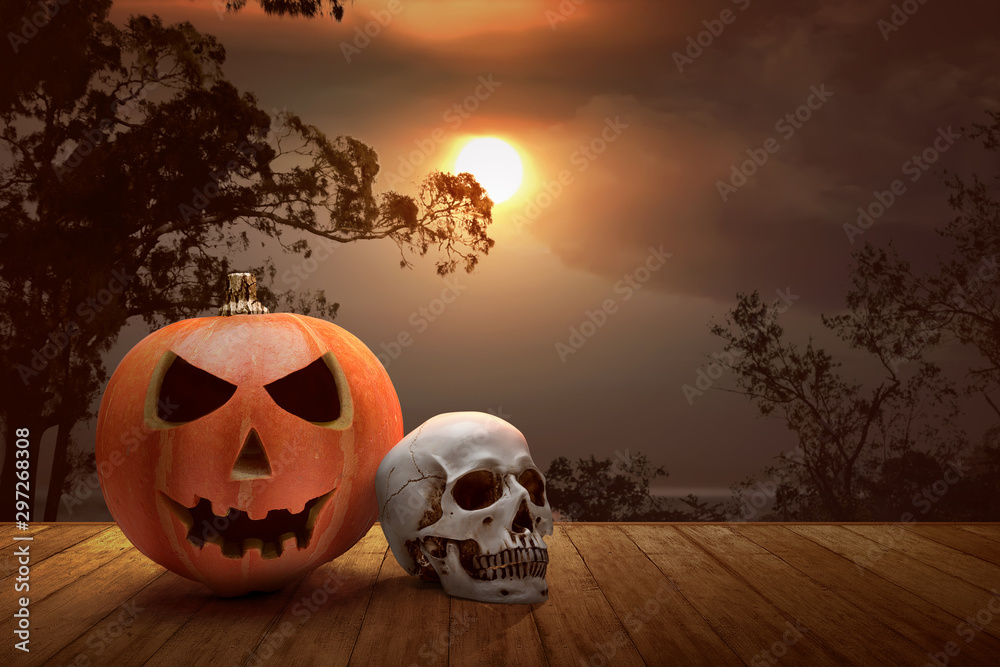Fototapeta premium Jack-o-Lantern and human skull on a wooden table