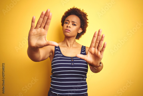 Beauitul african american woman wearing summer t-shirt over isolated yellow background doing frame using hands palms and fingers  camera perspective