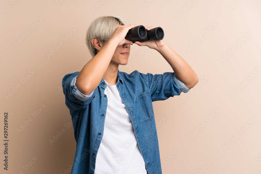 Young asian man over isolated background with black binoculars Young asian man over isolated background with black binoculars
