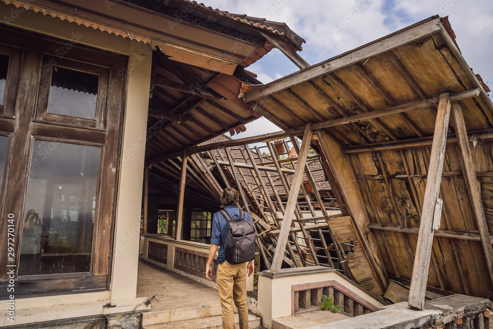 Obraz premium Man tourist in abandoned and mysterious hotel in Bedugul. Indonesia, Bali Island. Bali Travel Concept