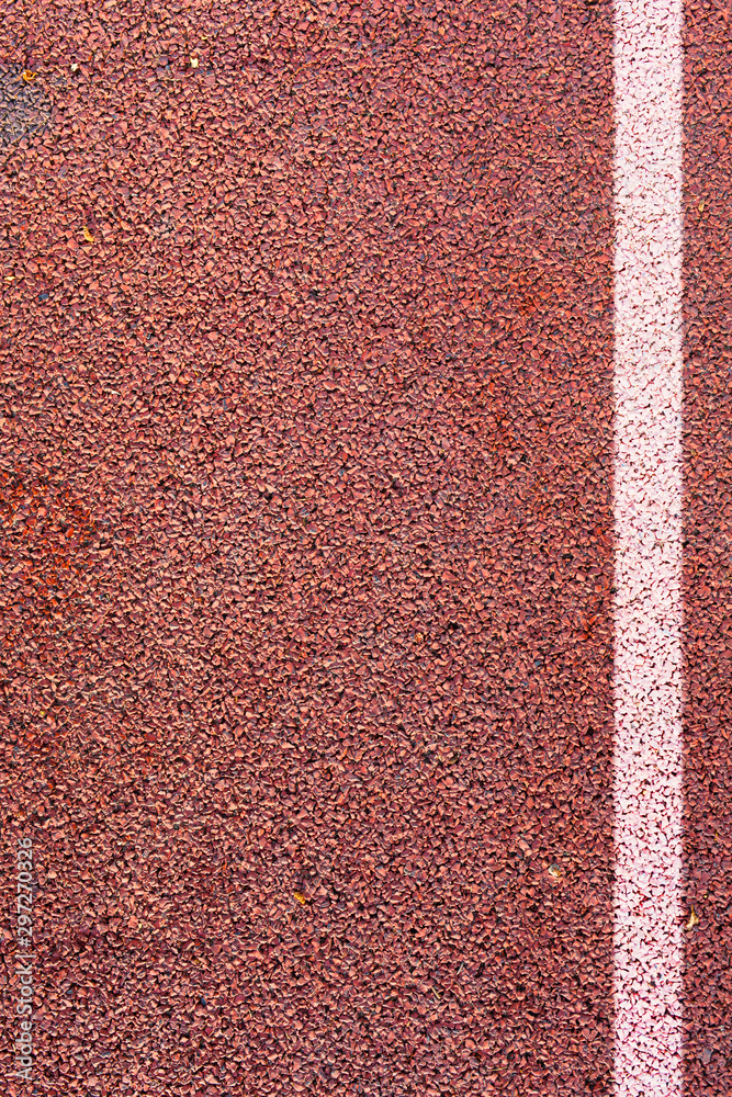 Fototapeta premium The white line on synthetic rubber protective covering. Surface of orange shock absorbing coatings from rubber chips as texture background.