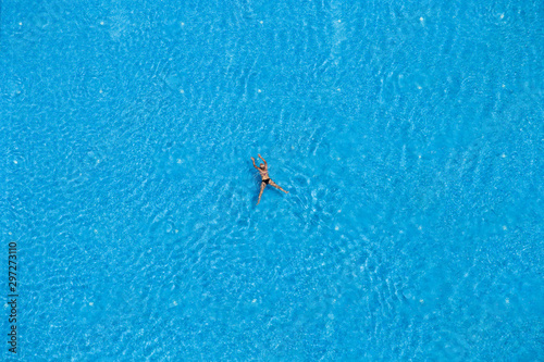 Woman swimming in a pool, top view