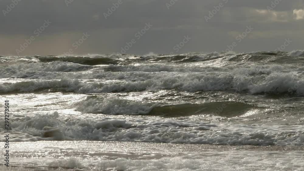 Slow motion shot of Baltic sea waves under grey sky during cold weather. Low angle shot. Slow motion shot of Baltic sea waves under grey sky during cold weather. Low angle shot.