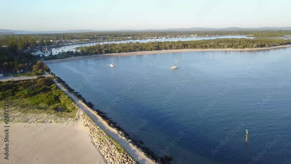 Drone Panning Above White Sandy Beach Towards Blue Water Bay With Sail Boats And Yachts In Yamba Australia Drone Panning Above White Sandy Beach Towards Blue Water Bay With Sail Boats And Yachts In Yamba Australia