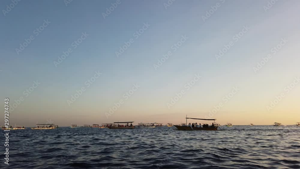 many Indonesian fishing boats are jukung, at dawn. tourists sit in boats and take pictures. very beautiful dawn. many Indonesian fishing boats are jukung, at dawn. tourists sit in boats and take pictures. very beautiful dawn.