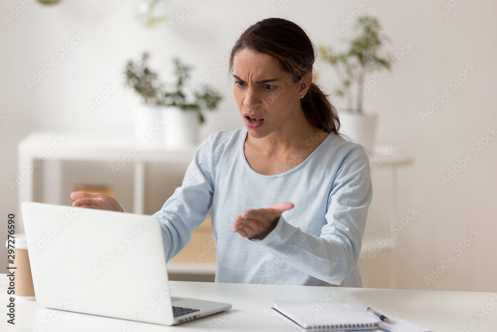 Angry millennial female worker employee irritated by slow computer work. Angry millennial female worker employee irritated by slow computer work.