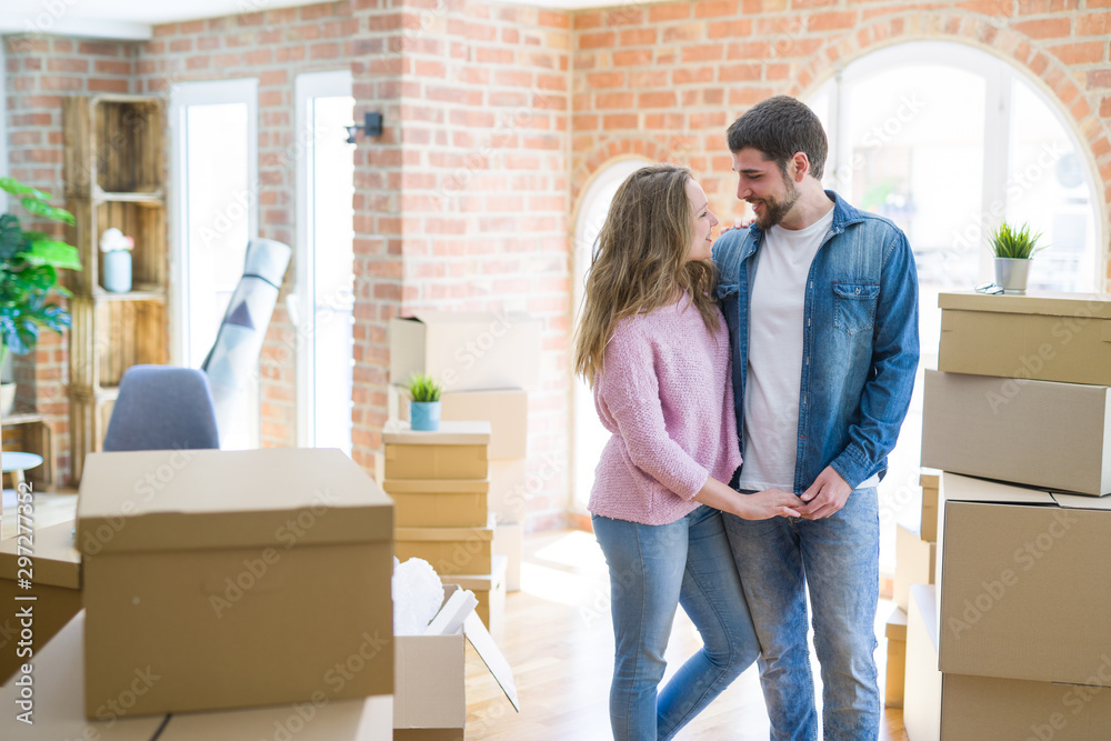 Young beautiful couple looking happy together moving to a new home Young beautiful couple looking happy together moving to a new home