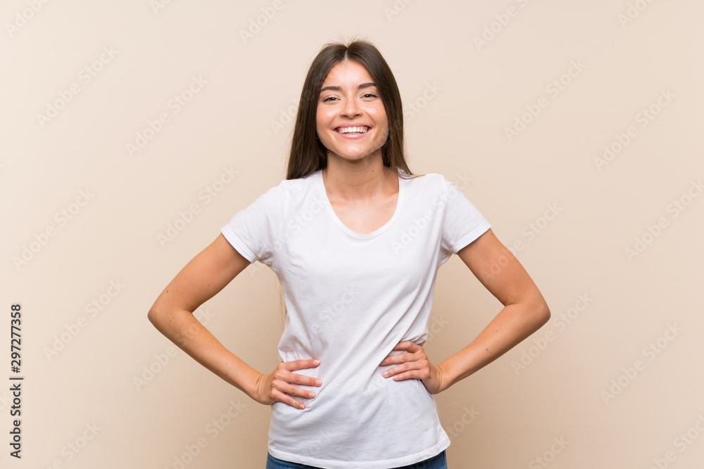 Pretty young girl over isolated background posing with arms at hip and smiling Pretty young girl over isolated background posing with arms at hip and smiling