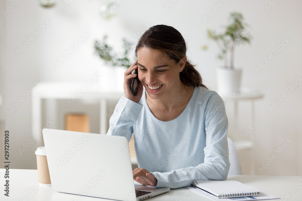 Young happy mixed race freelancer talking on smartphone with client. Young happy mixed race freelancer talking on smartphone with client.