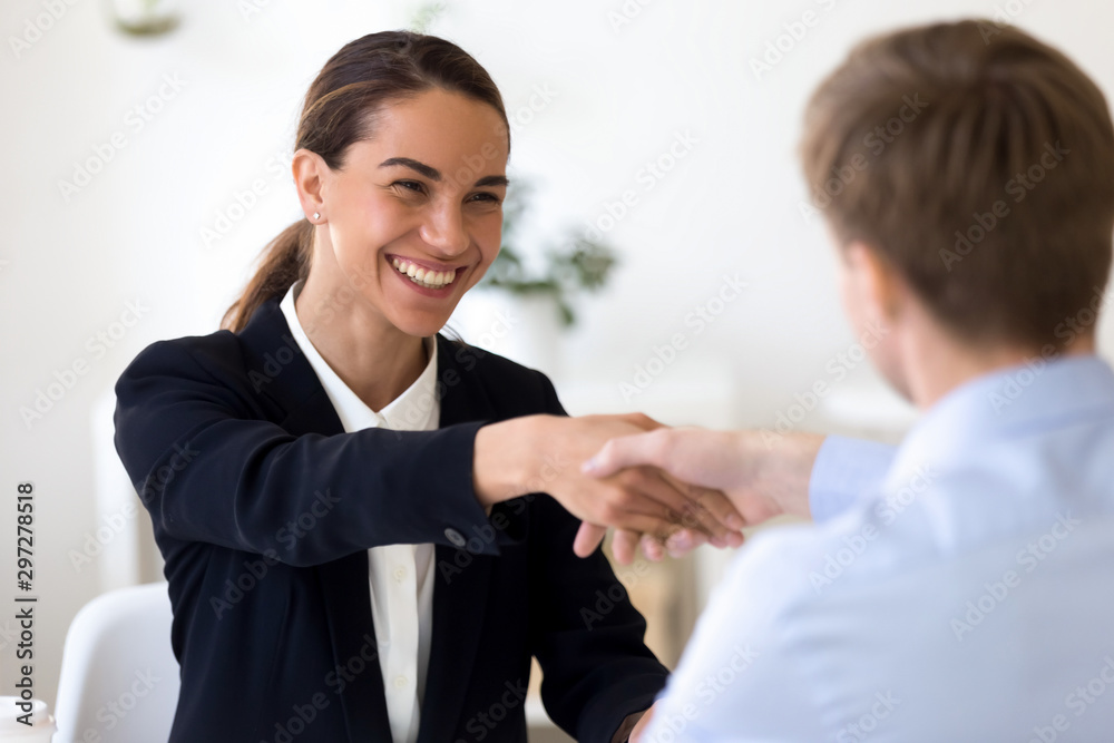 Happy female mixed race manager shaking hands with job applicant. Happy female mixed race manager shaking hands with job applicant.