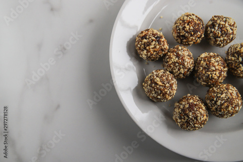 Energy balls with copy space. Homemade healthy dessert cooked with dates, nuts, dry fruits and cocoa. Organic dry fruits snacks on marble background