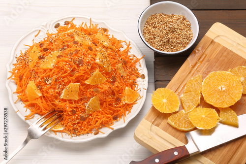 Fresh and healthy carrot and orange salad with sesame seeds on wooden background