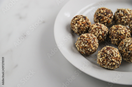 Energy balls with copy space. Homemade healthy dessert cooked with dates, nuts, dry fruits and cocoa. Organic dry fruits snacks on marble background
