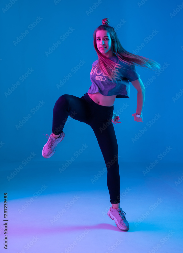 Young stylish girl dancing zumba in the Studio on a colored neon background.  Dance poster design. Stock Photo | Adobe Stock