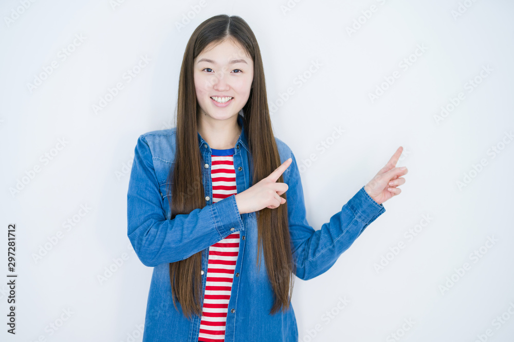 Beautiful young asian woman over white isolated background smiling and looking at the camera pointing with two hands and fingers to the side. Beautiful young asian woman over white isolated background smiling and looking at the camera pointing with two hands and fingers to the side.