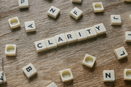 Word Clarity alphabet on wooden background.