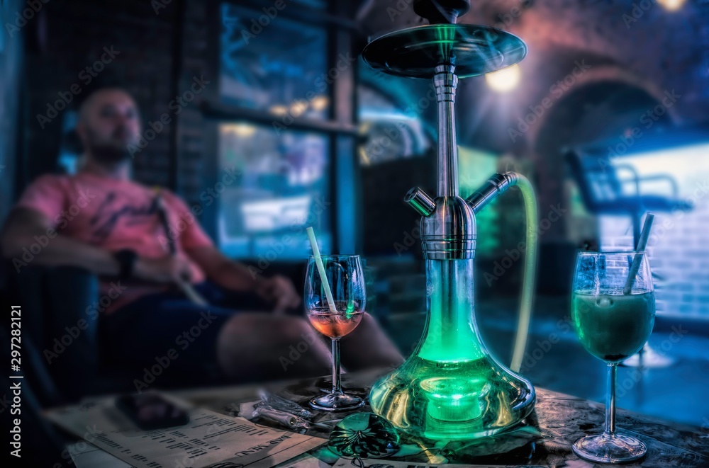 Budapest, Hungary - August 29, 2019: Tall chairs near the bar and a hookah on the table. Cafe interior in the old basement of a house in Budapest. Nightlife and entertainment in the capital of Hungary - obrazy, fototapety, plakaty 
