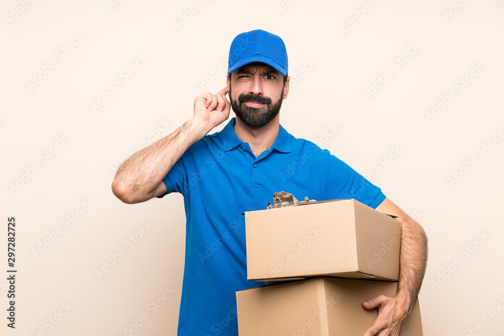 Delivery man with beard over isolated background frustrated and covering ears Delivery man with beard over isolated background frustrated and covering ears
