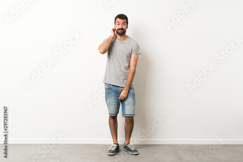 A full-length shot of handsome man with beard having doubts