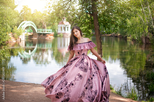 Fotografie Beautiful young woman in a dress of the 19th century by the pond