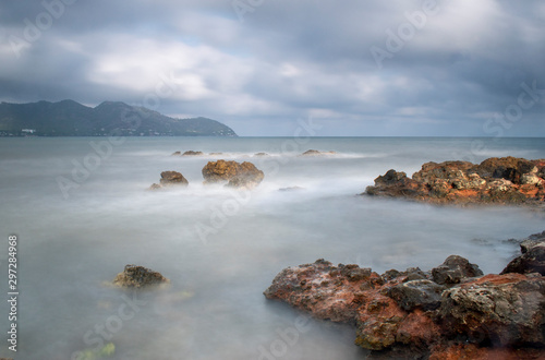 Seascape Cala Bona Majorca dramatic scene looking towards the headland with a calm and wistful effect over the sea.