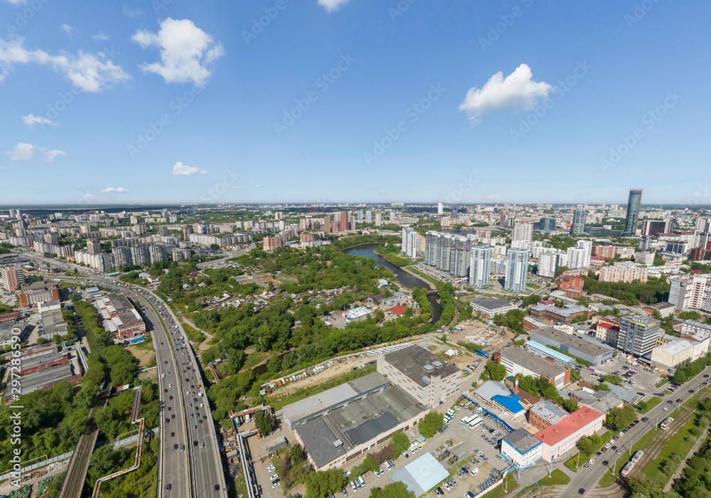 Summer city, road with cars and Iset river, a lot of trees, aerial view. Ekaterinburg, Verkh-Isetsky district, Russia