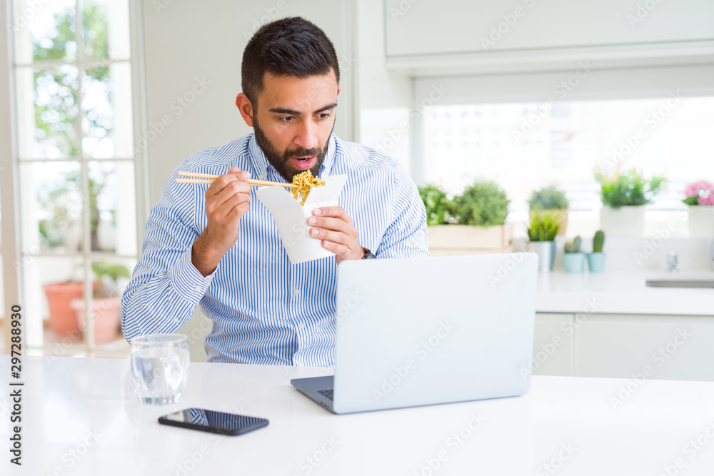 Business man eating asian food from delivery while working using computer laptop at the office Business man eating asian food from delivery while working using computer laptop at the office