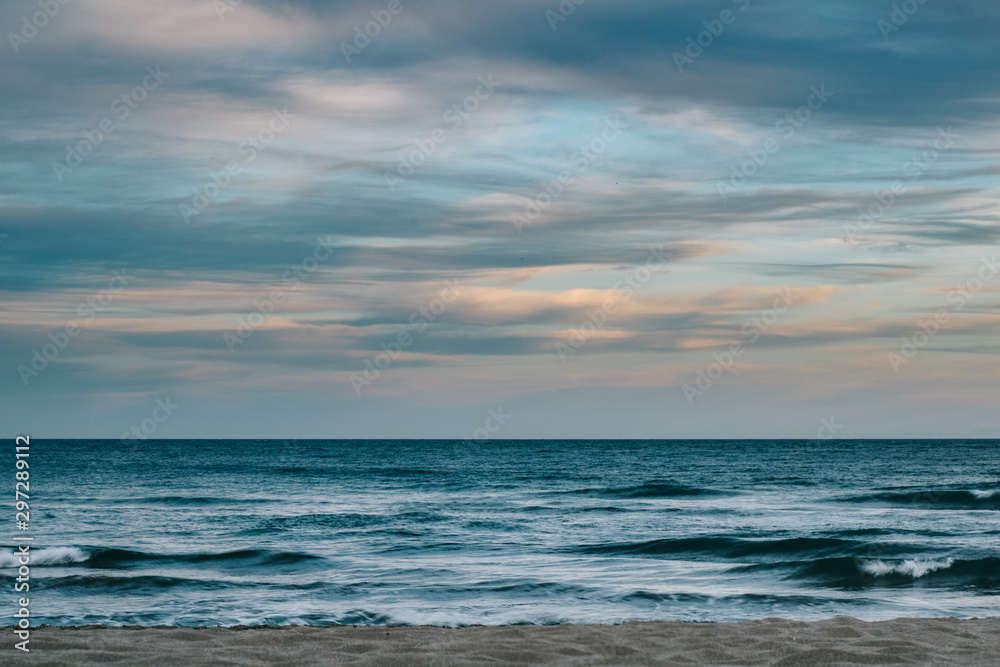 Photograph of the sea with clouds at sunset Photograph of the sea with clouds at sunset
