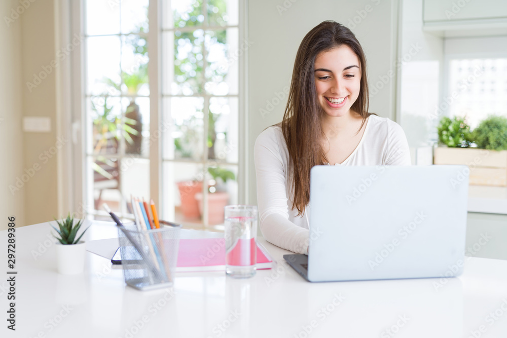Young beautiful woman smiling happy and working using computer laptop Young beautiful woman smiling happy and working using computer laptop