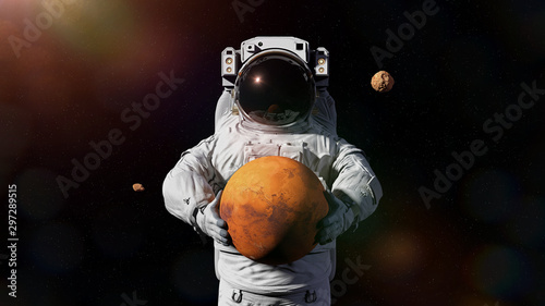 Fototapeta Naklejka Na Ścianę i Meble -  astronaut holding Mars,  Deimos and Phobos orbiting the planet 