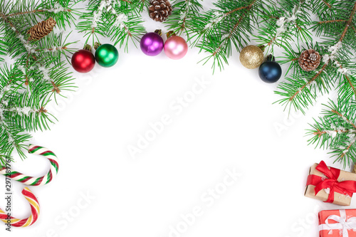 Christmas Frame of Fir tree branch with candy canes and balls isolated on white background with copy space for your text