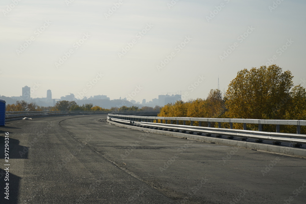 Unfinished bridge against the background of the silhouette of the city. Unfinished highway away city. Fender on the autobahn Unfinished bridge against the background of the silhouette of the city. Unfinished highway away city. Fender on the autobahn