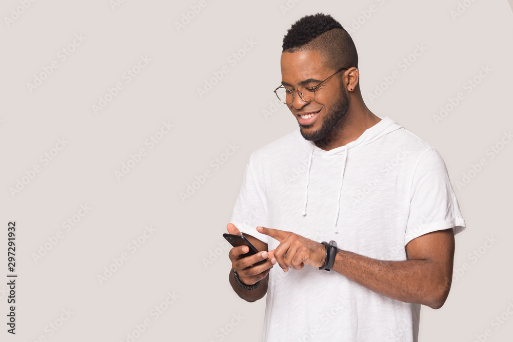 Smiling biracial man using modern cellphone with wireless internet Smiling biracial man using modern cellphone with wireless internet