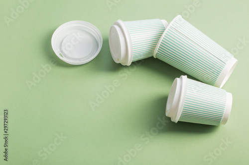 disposable paper cup with coffee on green background