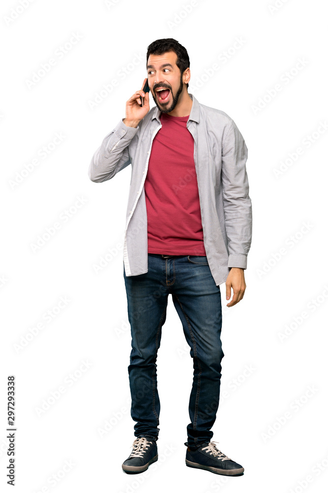 Full-length shot of Handsome man with beard keeping a conversation with the mobile phone over isolated white background Full-length shot of Handsome man with beard keeping a conversation with the mobile phone over isolated white background