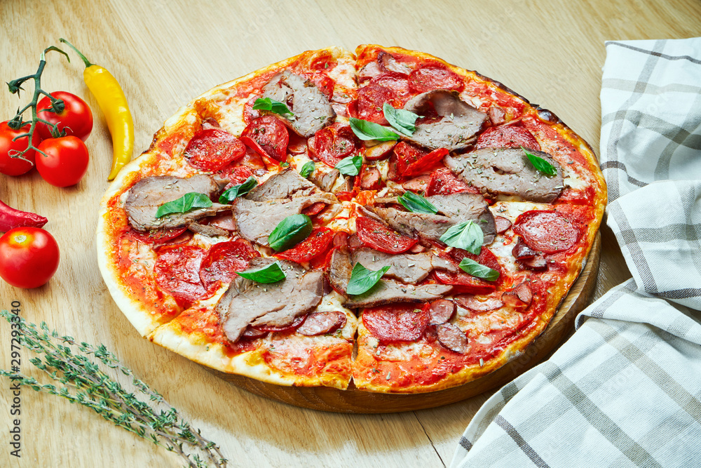 Italian, homemade pizza with meat, salami and hot pepper on a wooden table. Top view food with copy space. Flat lay