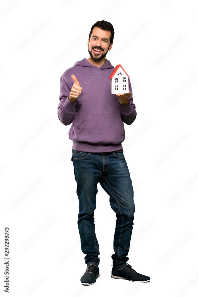 Handsome man with sweatshirt holding a little house Handsome man with sweatshirt holding a little house
