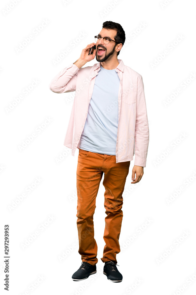 Full-length shot of Handsome man with beard keeping a conversation with the mobile phone over isolated white background Full-length shot of Handsome man with beard keeping a conversation with the mobile phone over isolated white background