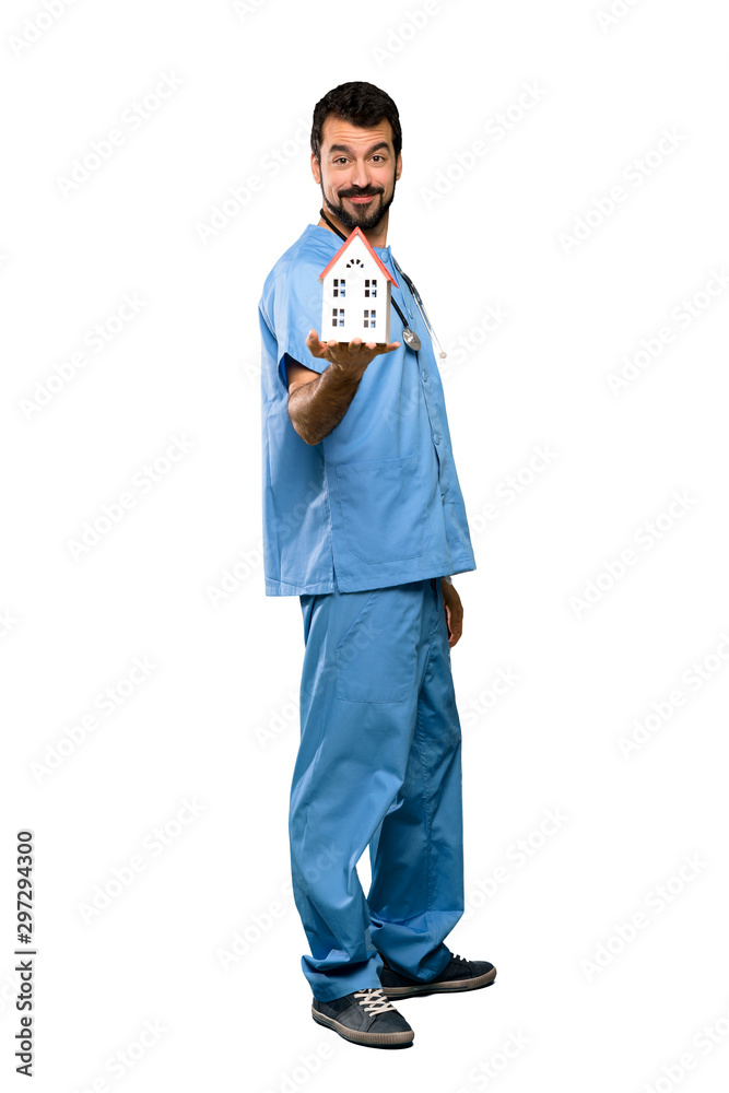 Surgeon doctor man holding a little house Surgeon doctor man holding a little house
