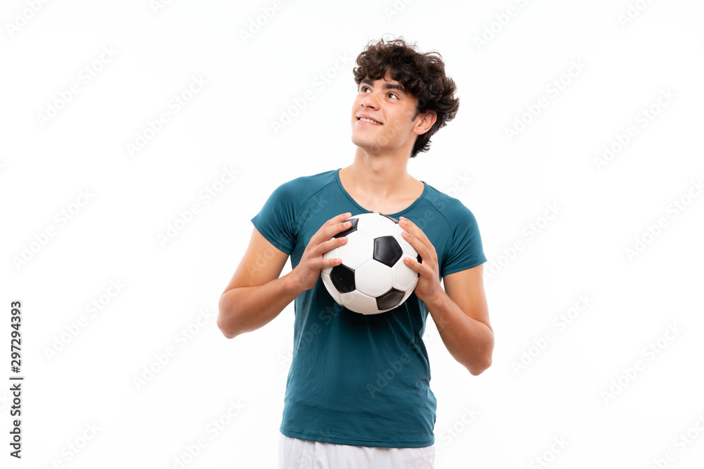 Young football player man over isolated white wall looking up while smiling