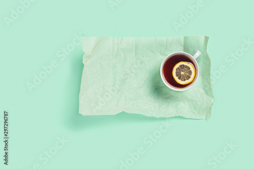 Mint background with one cup of tea on a baking paper.