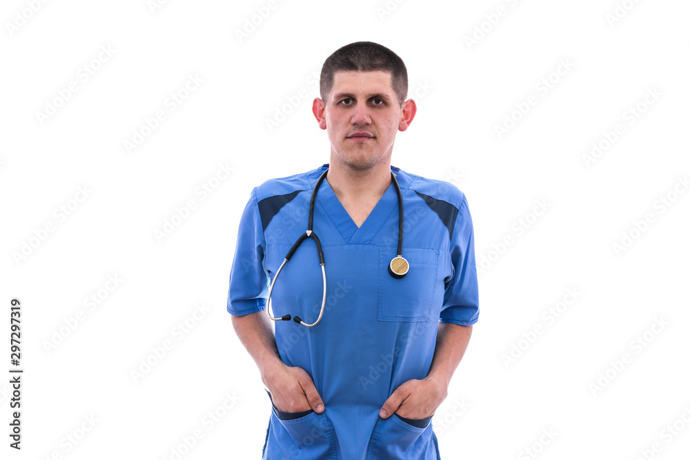 Doctor in uniform isolated on white. He is standing and putting his hands into pockets with stethoscope around his neck Doctor in uniform isolated on white. He is standing and putting his hands into pockets with stethoscope around his neck