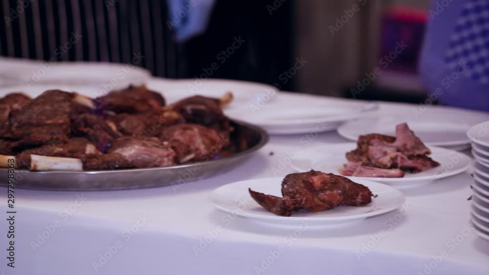 Waiter serving meat at restaurant. Close up of waiter serving food on plates in restaurant Waiter serving meat at restaurant. Close up of waiter serving food on plates in restaurant