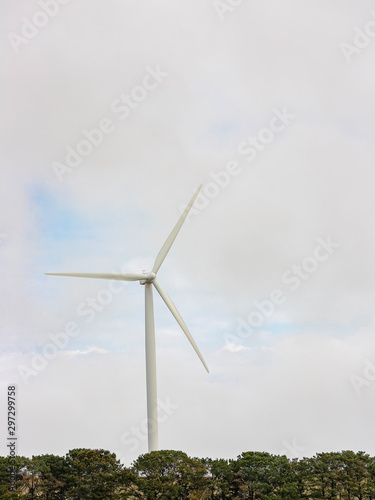A large wind turbine moving to create kinetic energy for renewable energy supply on a cloudy day located southeast of Lake George and north of Bungendore in New South Wales, Australia 