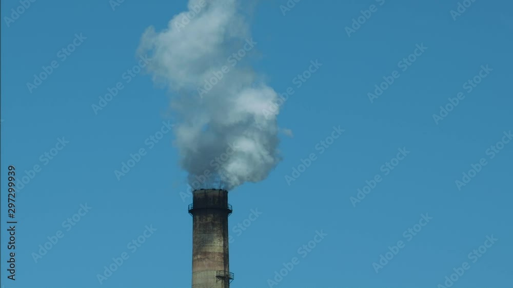 Smoking factory chimney against blue sky Smoking factory chimney against blue sky