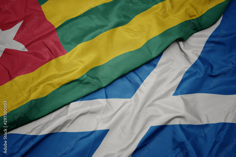 waving colorful flag of scotland and national flag of togo.
