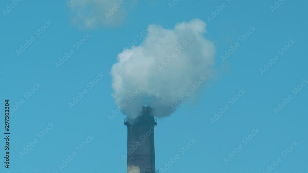 Smoking factory chimney against blue sky Smoking factory chimney against blue sky