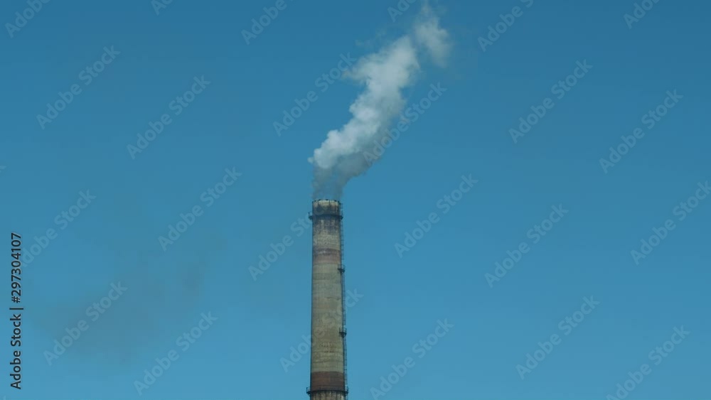 Smoking factory chimney against blue sky Smoking factory chimney against blue sky