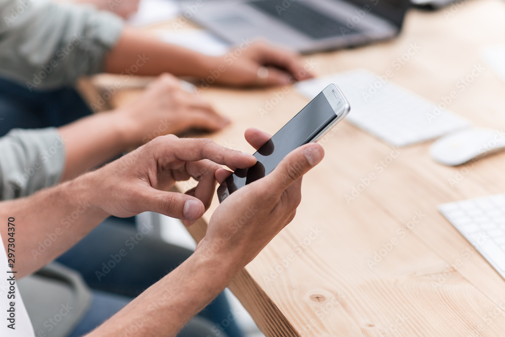 Obraz premium close up. businessman uses his smartphone in the workplace.
